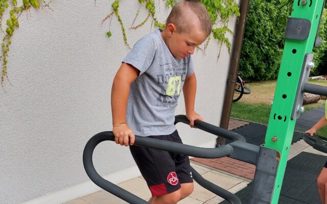 Kleiner Junge, der draußen Sport betreibt.