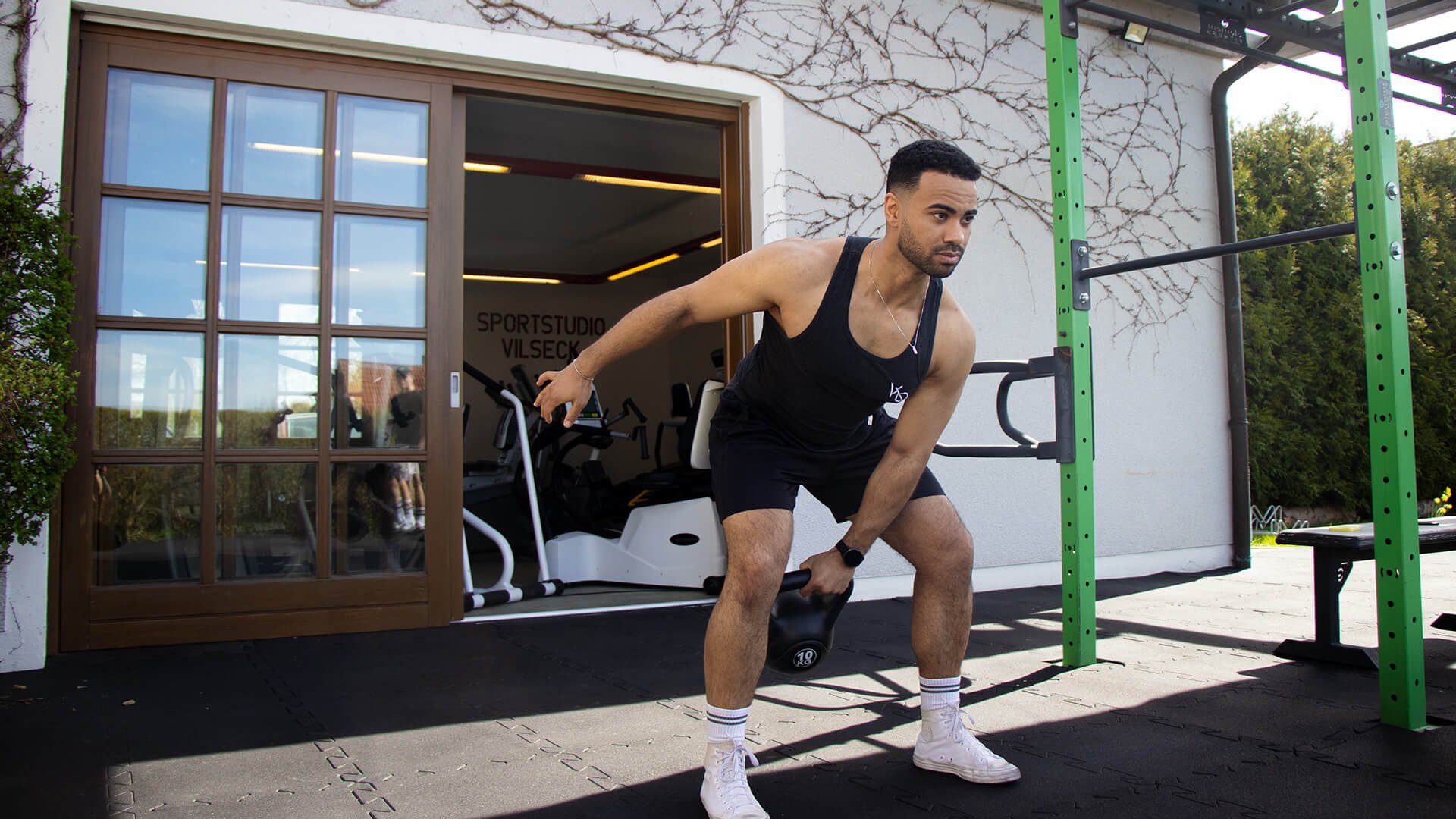 Junger Mann, der mit Kettle Bells trainiert.
